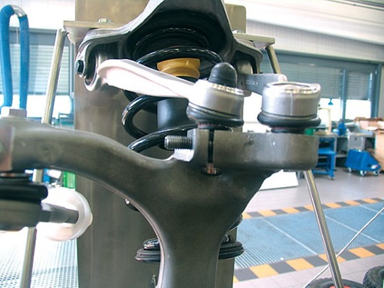 Posicionamiento del cilindro del distanciómetro V.A.G. 1925 sobre el soporte del eje del eje delantero del vehículo