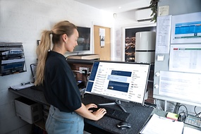 Woman standing at the counter of a workshop reception using the ZF[pro]Manager app