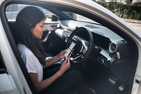 Image of a woman within a car checking her phone via ZF[pro]Manager