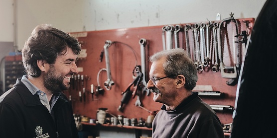 Two mechanics talking and smiling