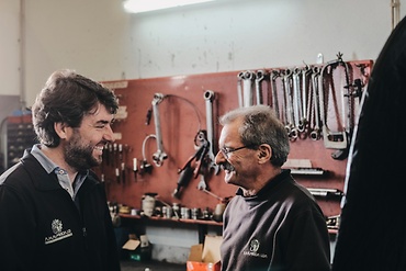 two mechanics talking and smiling