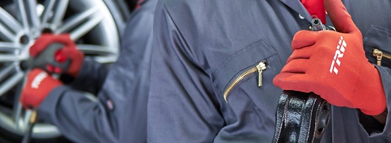 Man in blue overall and red trw glove 