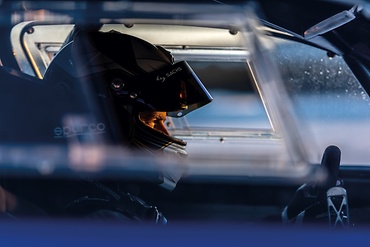 Joachim Waagaard in a race car wearing a helmet