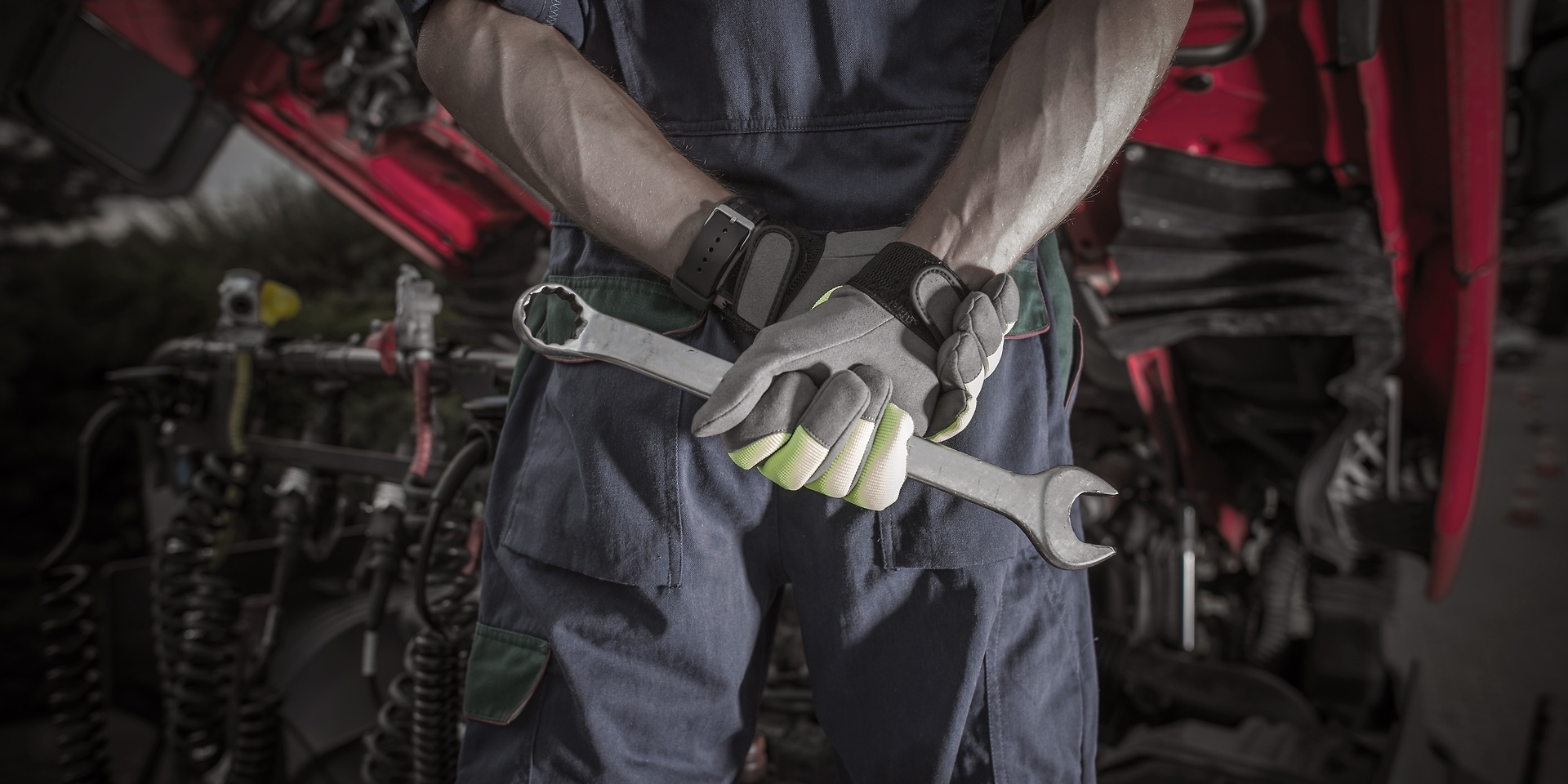 mechanic with tools behind his back 