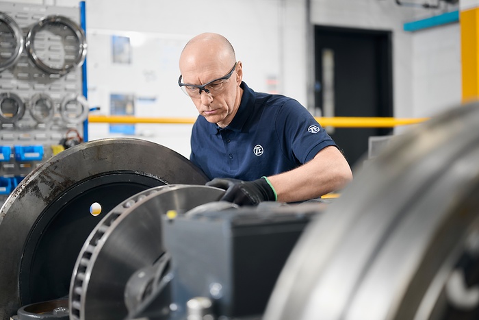 employee concentrated on working with big rail item