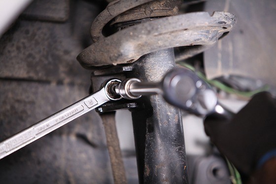 Loosen fastening nut at suspension strut and remove it.